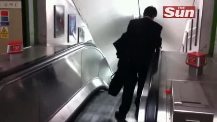 Подпийнал бизнесмен се мъчи да се изкачи на ескалатор!