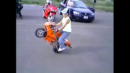 Малък пич кара мини мотоциклет на задна гума