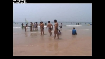 Three huge bodybuilders at the beach