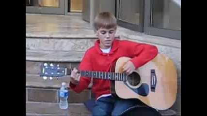 Justin Bieber, тъжното момче, стоящо на стълбите на малък градски театър, свири на китара и пее 