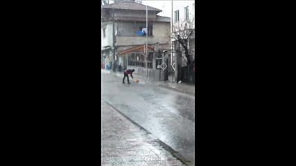 Метене на улицата по време на обилен дъжд