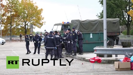Slovenia: Armed soldiers guard camp as refugees board northbound buses
