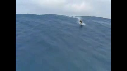 човек сърфира по огромно цунами 