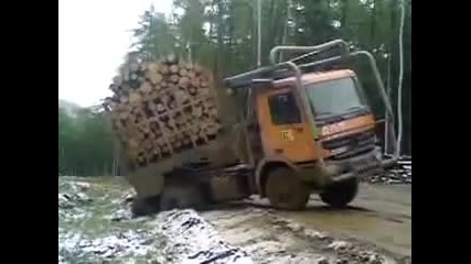 Дълъг камион натоварен с дърва се преобръща след неуспешен опит да излезе от канавка край път