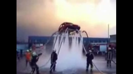 Пожарникари Мият Лек Автомобил Отдолу по Много Интересен Начин с Вода с Пожарникарските Шлангове Като я Вдигат Във Въздуха