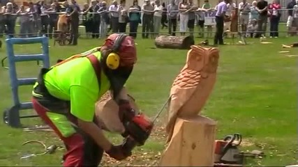 Човек прави бухал от дърво с моторна резачка