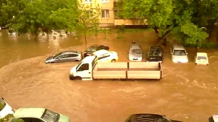 Превозни средства преминават през наводнена улица