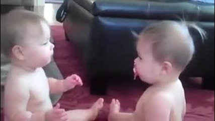 Малки сладурани близначета спорят за биберон.