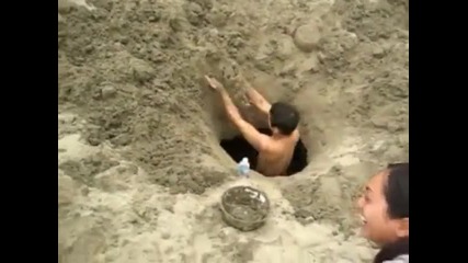 Копаене на голяма дупка на плажа 