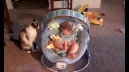 Бебчето се залива от смях докато котката си играе с играчките му