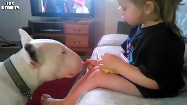 Сладко момиченце храни куче..
