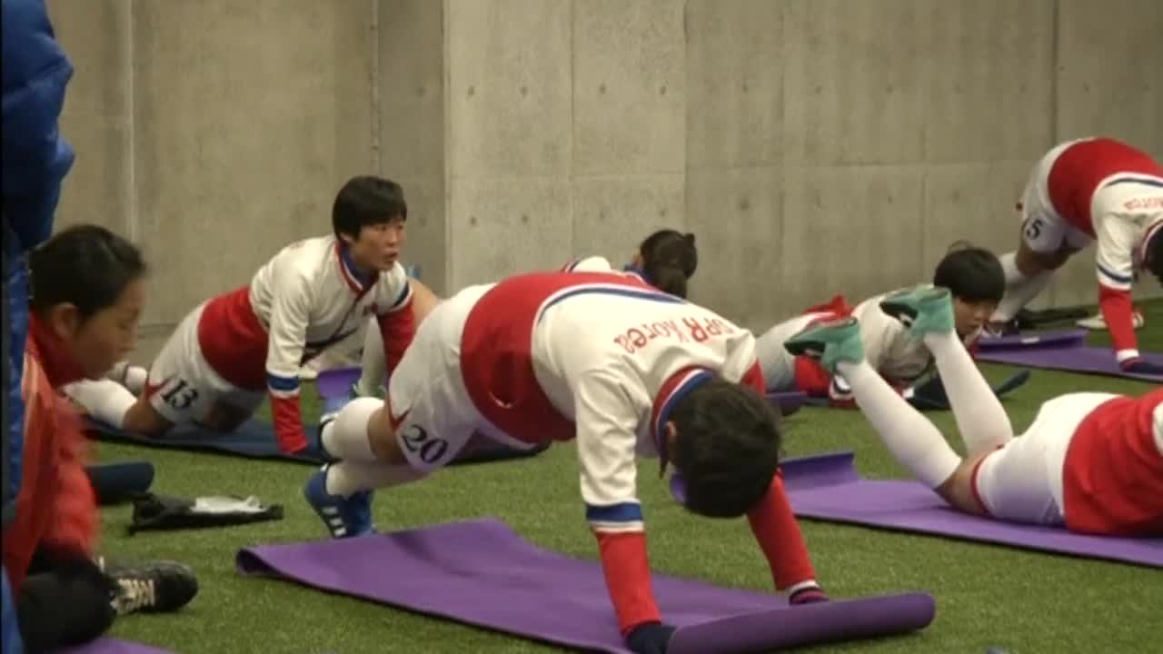 Севернокорейски футболисти в Япония, загряват с йога