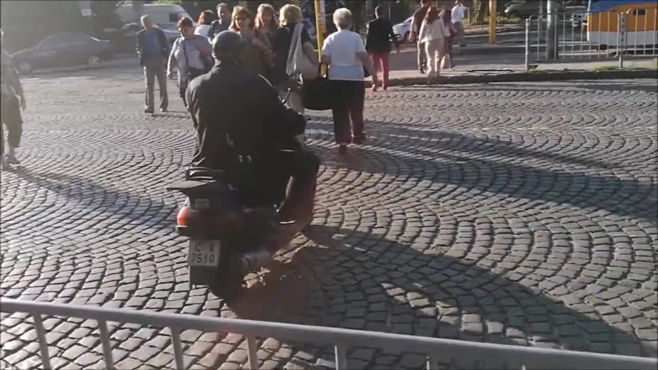 Униформен полицай със скутер по тротоар