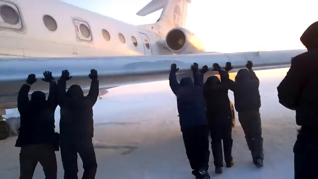 Пасажери бутат закъсал самолет