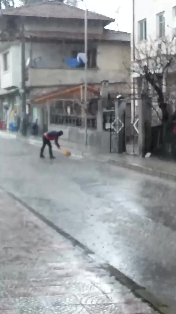 Метене на улицата по време на обилен дъжд